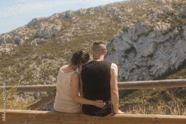Obraz Young couple in love on a gazebo with their backs turned