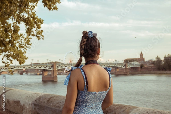 Obraz Woman on her back with the background of a bridge in Toulouse, France