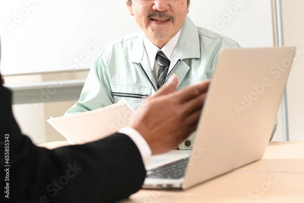 Fototapeta オフィスで会話をする笑顔の中年の男性作業員達
