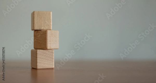 Fototapeta Three blank wooden blocks stacked on a blurred background.