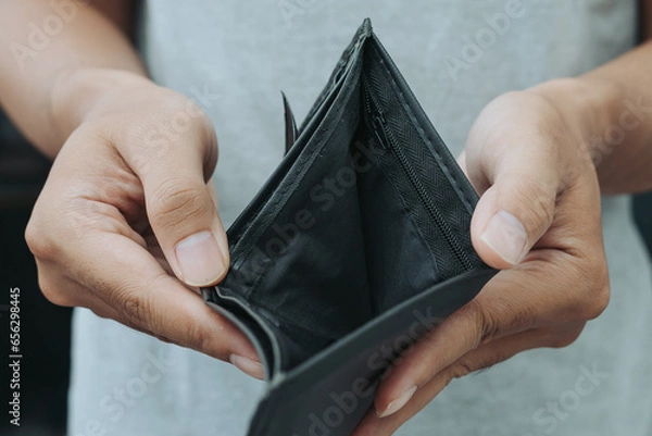 Obraz Hands holding black empty wallet with no money inside.