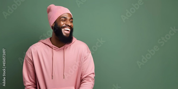 Fototapeta Colorful studio portrait of an ethnic man smiling happily. Green and pink. Copy space