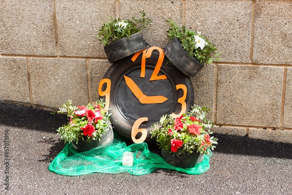 Obraz Clock made with car tires and flowers on "Costitx en Flor" (Costitx in bloom) Flower Fair, Majorca, Spain