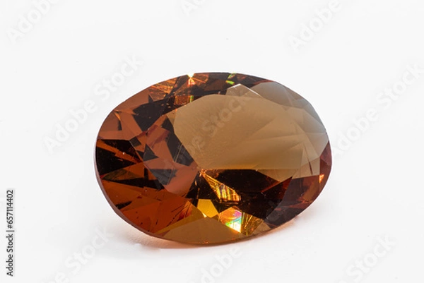 Obraz Colour changing diaspore, Turkish Zultanite oval faceted on white background under white artificial light. Yellow to orange color shift zultanite.
