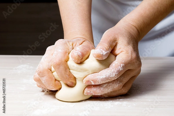 Fototapeta Hands kneading a dough
