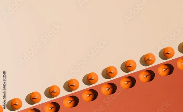Obraz Halloween flat lay idea, minimal pattern composition. Fresh pumpkin on earthy orange and beige background. Optimistic fall season concept.