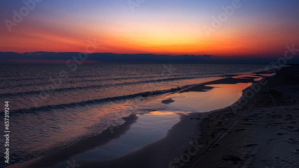 Obraz Sunset panorama with orange sky and reflection on the beach and water. Mediterranean, Camargue, Gard, France.