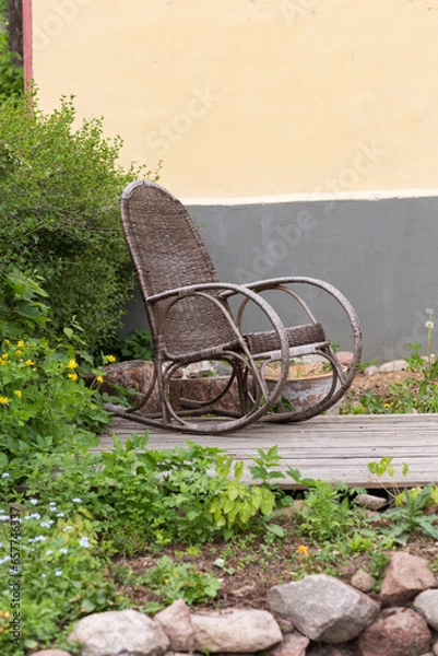 Fototapeta an empty old rocking chair stands in the courtyard of the house  