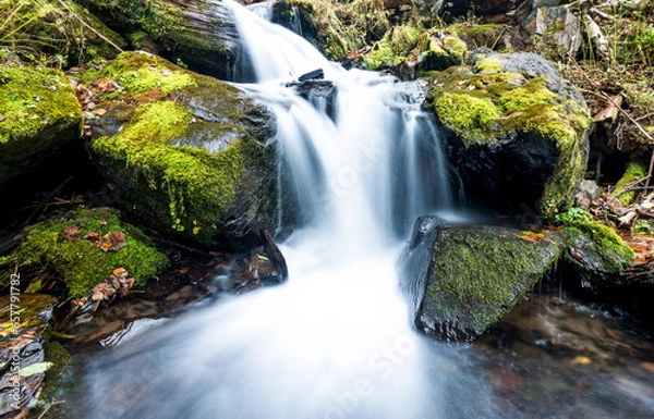 Obraz Blurred waterfall throughing mossy rocks