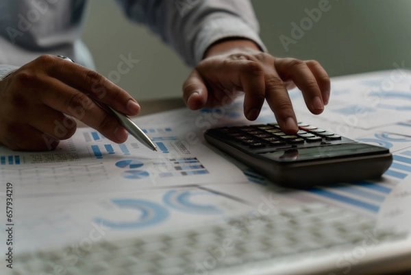 Fototapeta man using a calculator accountant working on desk budget and loan Close up Accounting analysis, tax finance, bank income savings budget