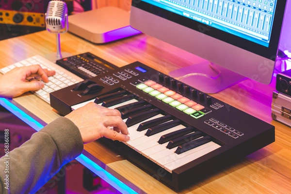 Obraz male musician, producer, arranger hands playing midi keyboard for recording music on desktop computer. music production concept
