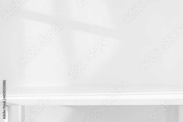Fototapeta Empty white desk with morning light and shadows of windows with copy space, summer concert. Blurred backdrop abstract background for display product.