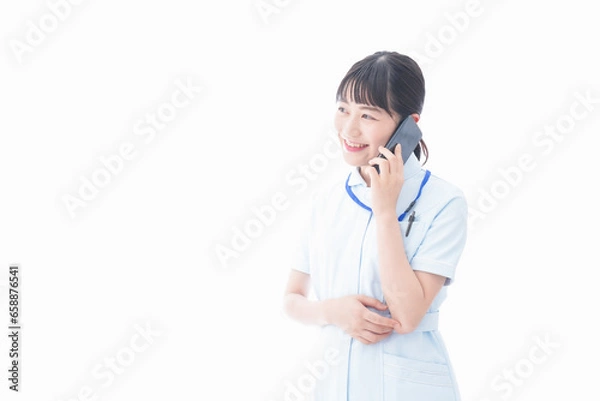 Fototapeta スマホを使う若い看護師
