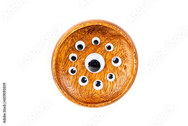 Obraz Small googley eyes surround a large single eye in a wooden bowl