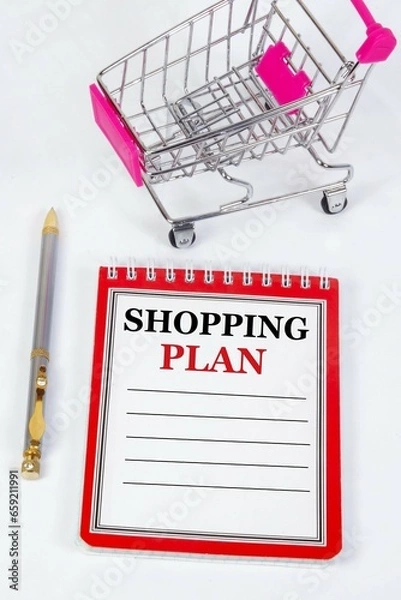 Fototapeta Shopping plan. An inscription in a notebook on the background of a shopping basket in a store.