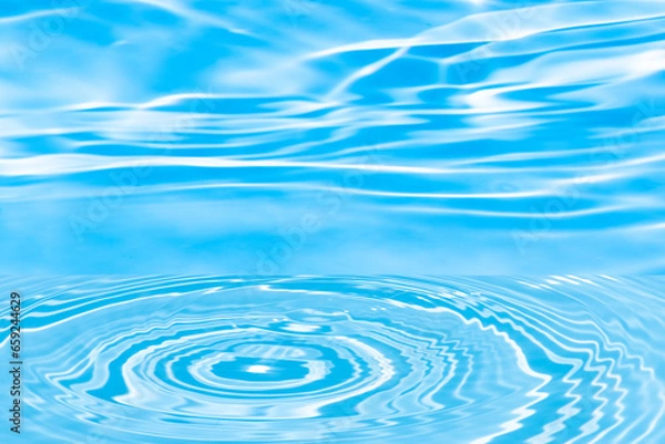 Fototapeta Defocus blurred transparent blue colored clear calm water surface texture with splashes reflection. Trendy abstract nature background. Water waves in sunlight with copy space. Blue watercolor shine.