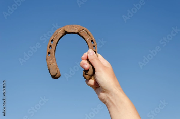 Obraz hand hold vintage horseshoe on blue sky background