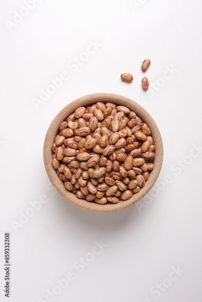Fototapeta dried beans in wooden bowl on white background shot from above