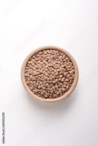Fototapeta lentils in wooden bowl on white background shot from above