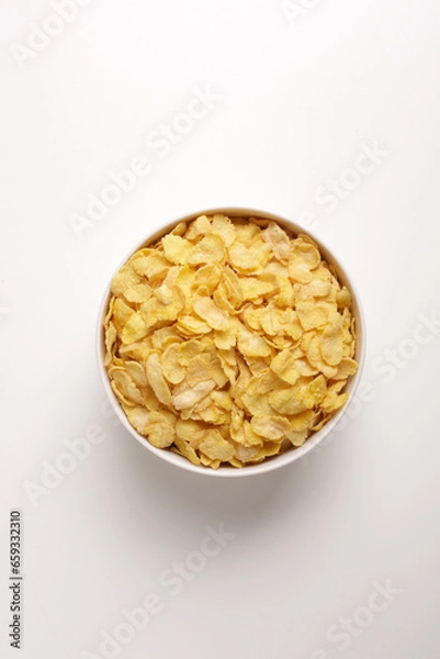 Fototapeta corn flakes in round white plate on white background taken from above