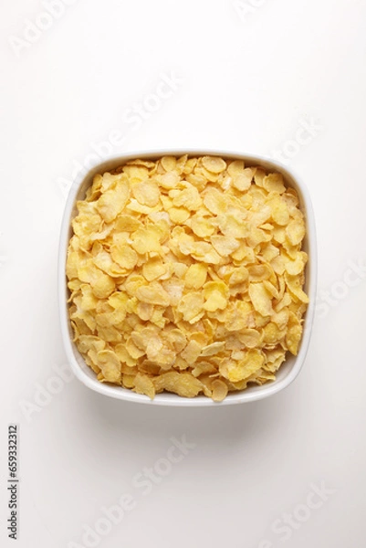 Fototapeta corn flakes in a square plate on a white background taken from above