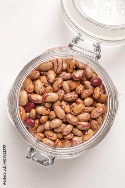 Fototapeta beans borlotti in a glass jar taken from above on a white background