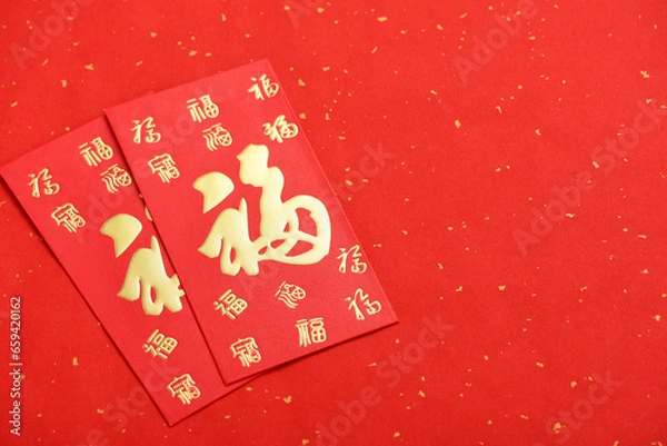 Obraz There are red envelopes on the red background of the Chinese New Year. The Chinese meaning in the picture is: good luck