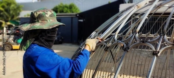 Obraz Technician using welding equipment for wrought iron work