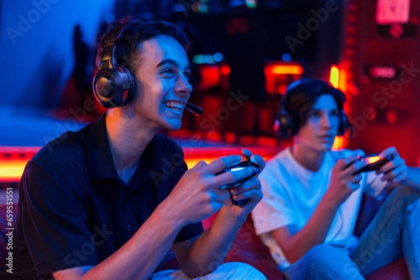 Obraz Two teen friends are playing a game console