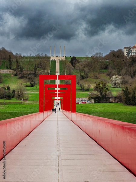 Obraz Threatening clouds over the Red Bridge and the 12 columns of the Major Axis in Cergy. Val d'Oise, France