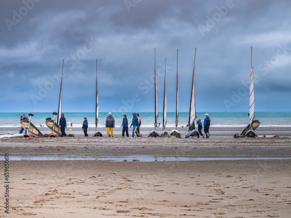 Obraz Activities on the beach at low tide. Men and women ready to go sand yachting. Coastline of Upper Normandy, France