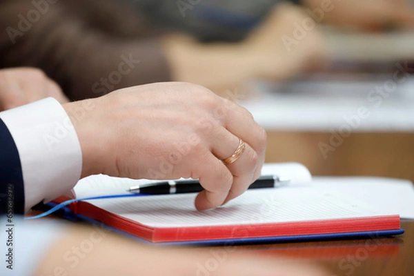 Fototapeta person writing on a notebook