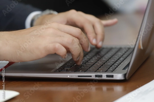 Obraz person typing on a laptop