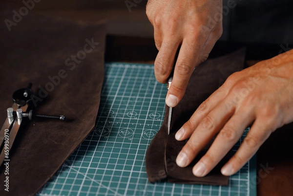 Fototapeta Closeup Hand of Tailor, cobbler use natural brown leather, shoemaker working with skin textile in workshop