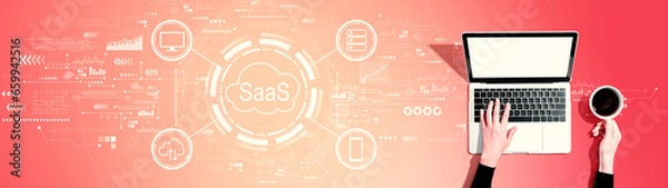 Fototapeta SaaS - software as a service concept with person using a laptop computer