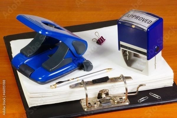 Fototapeta Documents in a folder, a hole punch and a seal. Paper clerical office work.