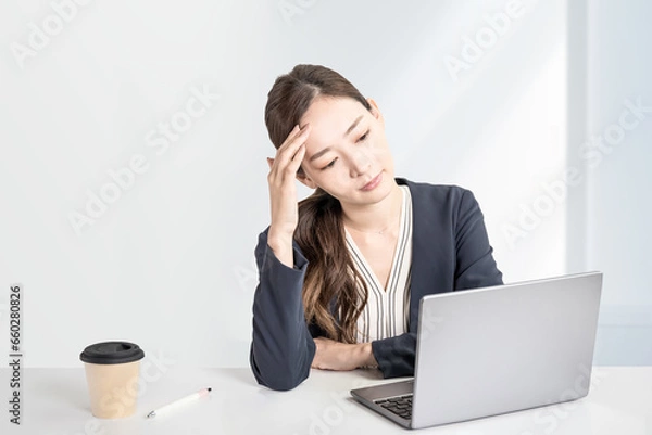 Obraz 管理職の女性は一人で悩む、頭が痛い。白いシンプルなオフィスの背景