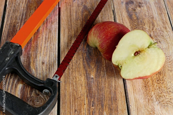 Fototapeta red apples and an old saw on wooden background