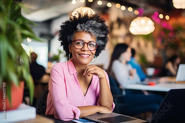 Fototapeta portrait of an elegant middle age black  woman with laptop posing on camera in a coworking space indoor  