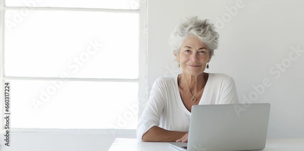 Fototapeta portrait of an l elderly  woman with long grey and white hair, working with computer pc in office