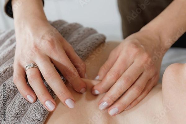 Fototapeta buccal facial and neck massage, close-up, cosmetologist makes woman a procedure on a massage table in a spa salon