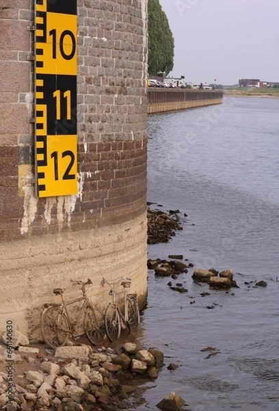 Obraz Very low water in the river Rhine reveals old rusted bikes  ( John Frost bridge in Arnhem, the Netherlands)