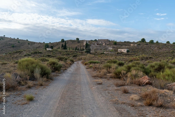 Obraz dirt road that goes to some old abandoned mine buildings