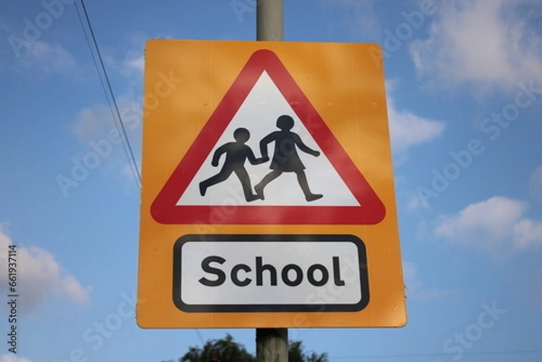 Fototapeta Yellow and red school sign UK blue sky in background with clouds