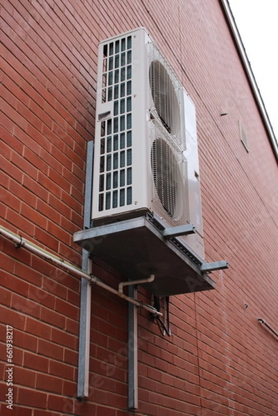 Fototapeta Air conditioner unit installed outside on a brick wall