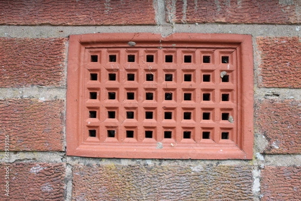 Fototapeta Brick wall with a close up showing a ventilation brick