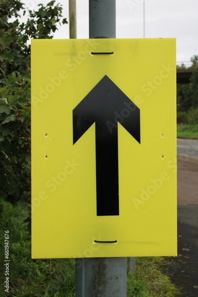 Fototapeta Yellow sign with Black arrow used for marathon runners to indicate route direction to runners