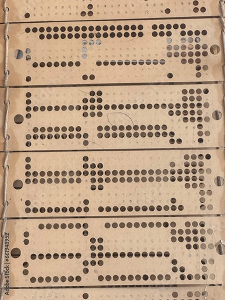 Obraz Close up view of punched cards on old working jacquard industrial weaving loom.