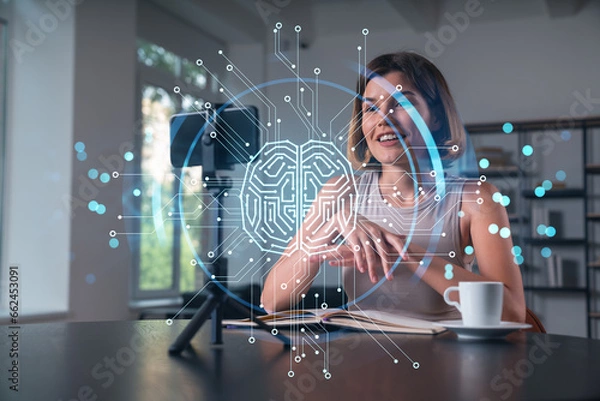 Fototapeta Happy woman is making video blog using smartphone on a tripod explaining with hands at office workplace. Concept of online stream, business education, conference call. Ai technolgy hologram