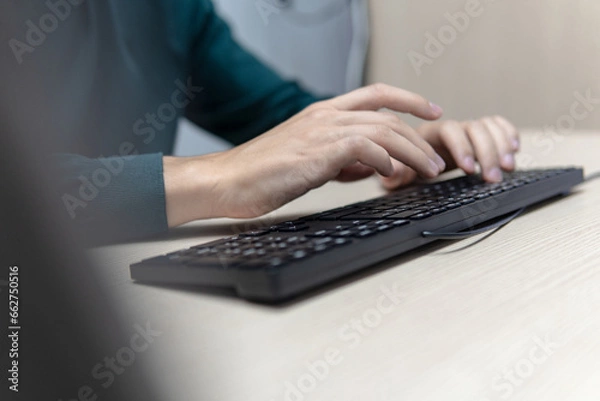 Fototapeta Businessman's hands typing on a computer keyboard at a desk, business concept and internet communication.